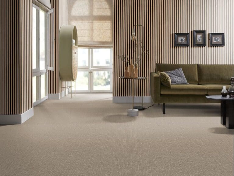 Woonkamer met houten wandpanelen, groene bank en beige kamerbreed tapijt