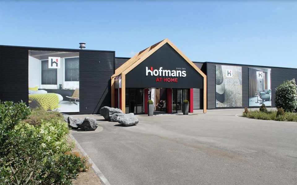Buitenkant van de winkel van Hofmans at Home in Cuijk met entree en parkeerplaats