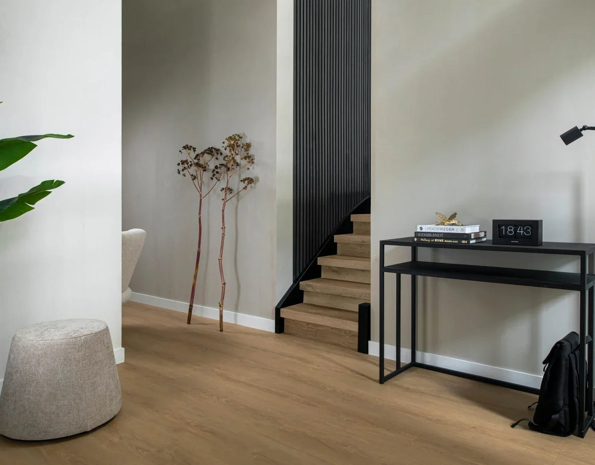 Hal met eiken houtlook vloer, houten trap en zwarte sidetable