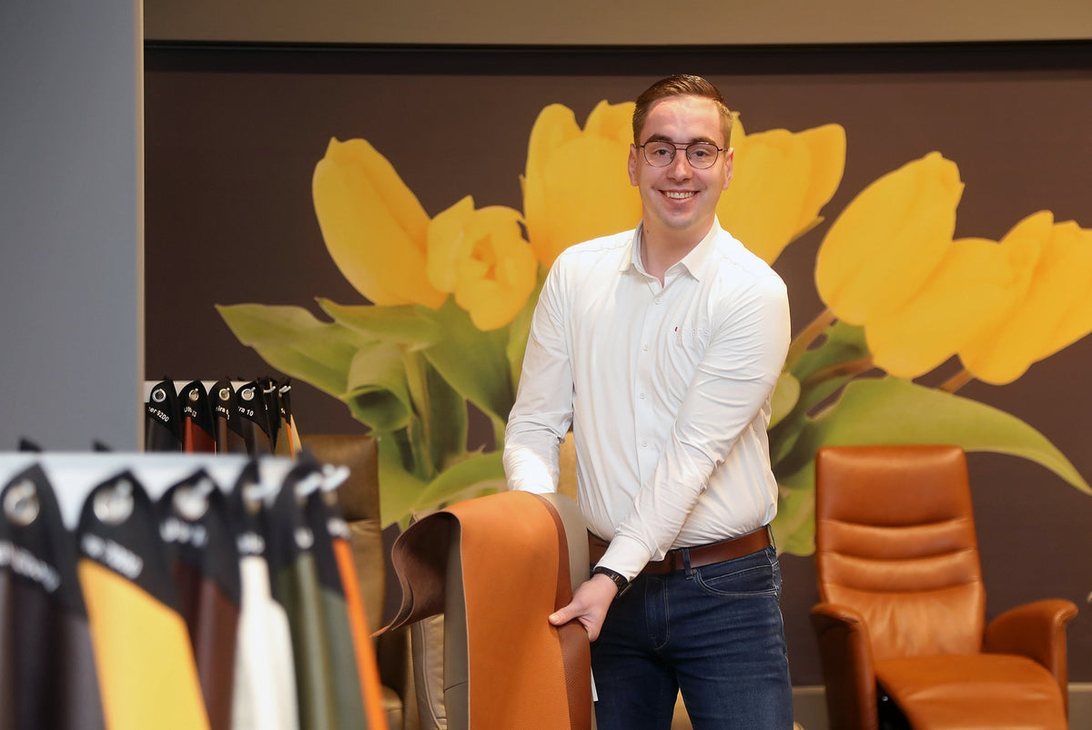 Adviseur Robert toont lederstalen bij relaxfauteuils in de showroom van Hofmans at Home