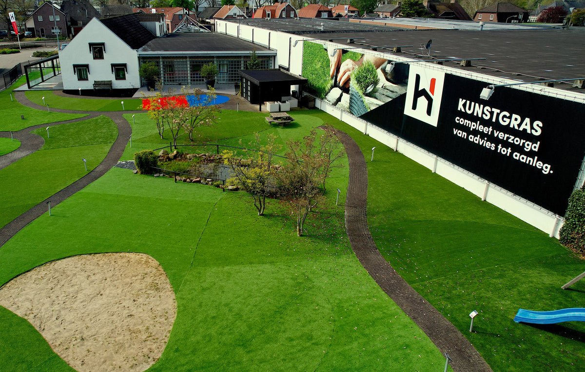 Showtuin van Hofmans at Home met kunstgras, paden en zandvlak van bovenaf gezien