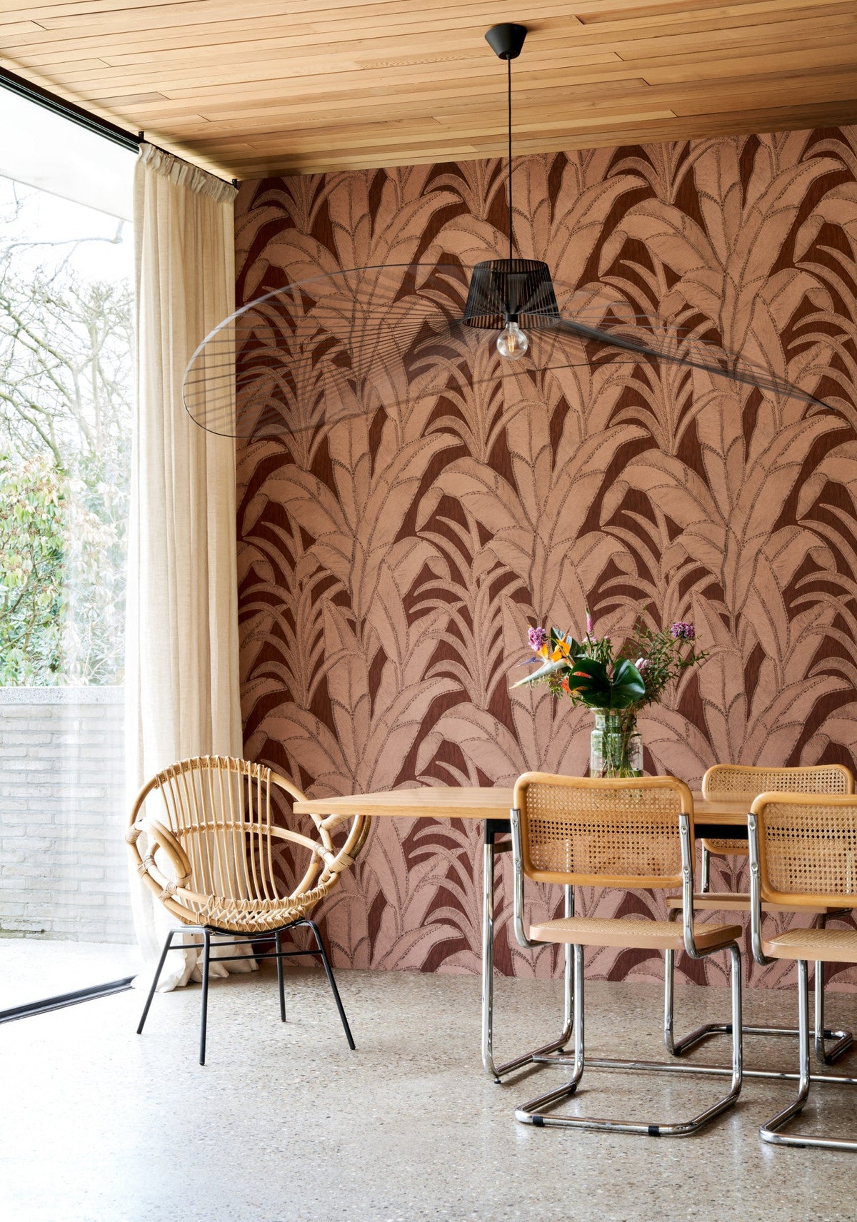 Eetkamer met Manila Botanic behang met bladmotief, rotan stoelen en houten tafel