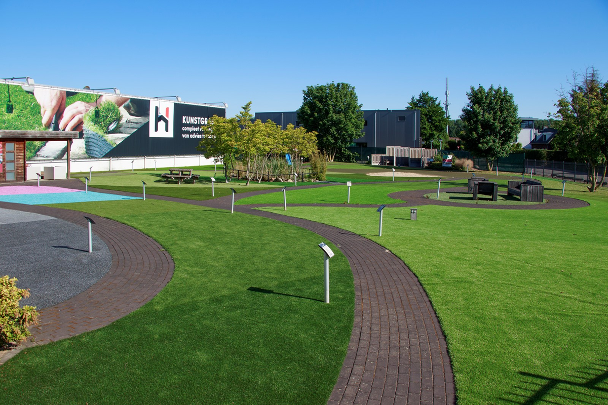 Kunstgras showtuin van Hofmans at Home met slingerende paden en verschillende soorten kunstgras