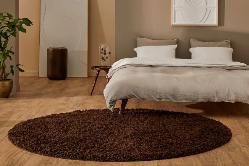 Slaapkamer met rond bruin hoogpolig vloerkleed Berbero Lungo voor een tweepersoonsbed
