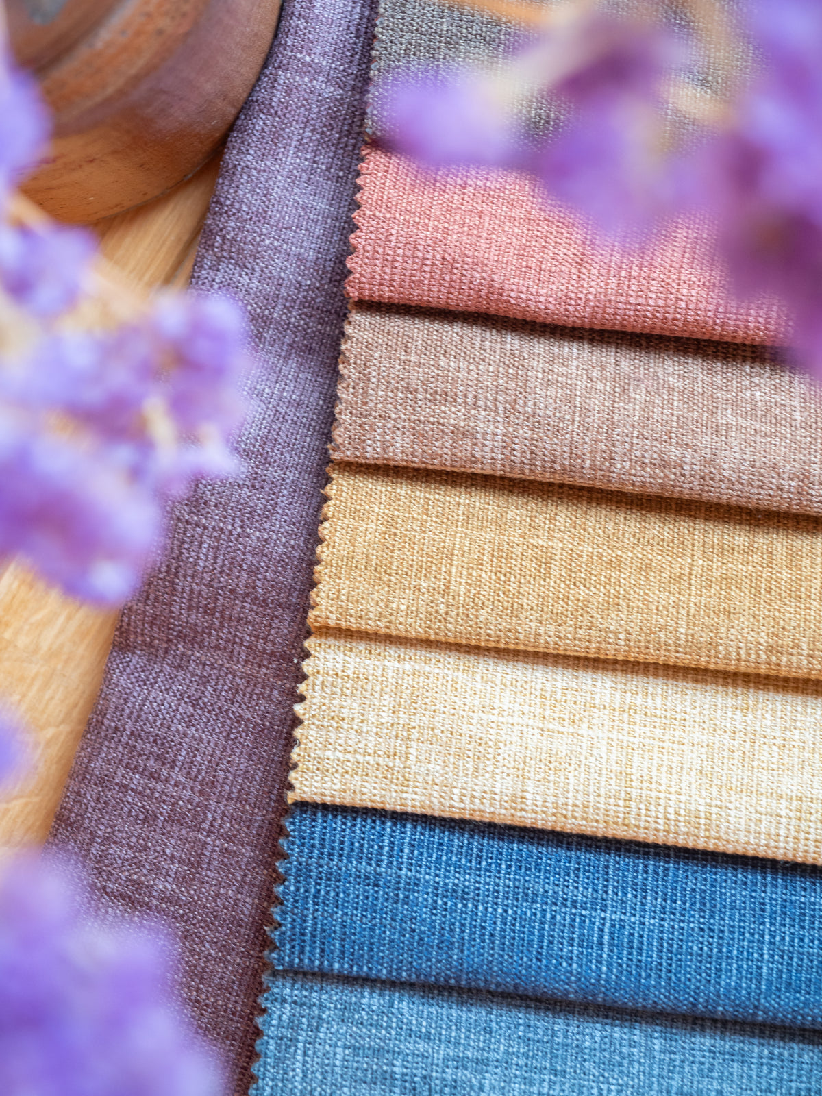 Gordijnstoffen in pasteltinten roze, oker, beige en blauw naast lavendeltakjes