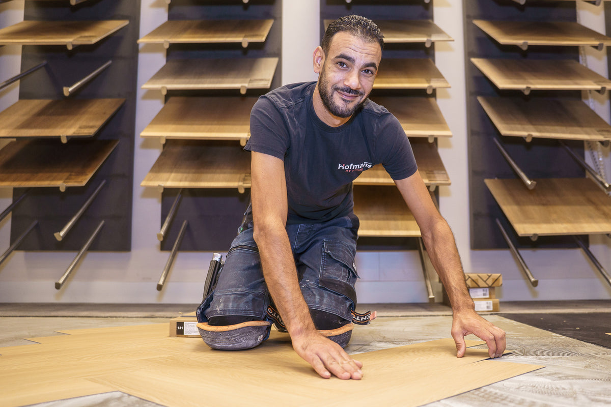 Stoffeerder van Hofmans at Home legt een houtlook vloer voor de vloerstalenwand