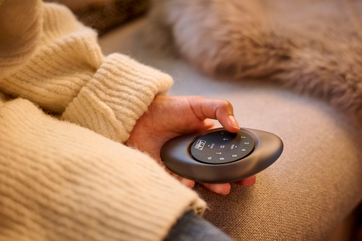 Hand bedient de Luxaflex PowerView afstandsbediening voor slimme raamdecoratie