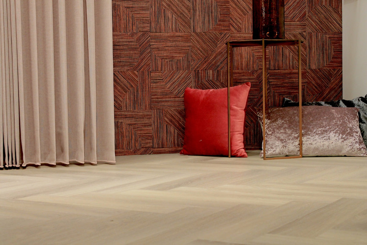 Roomset met rood-bruin behang, beige gordijnen en lichte visgraatvloer in de showroom van Hofmans at Home