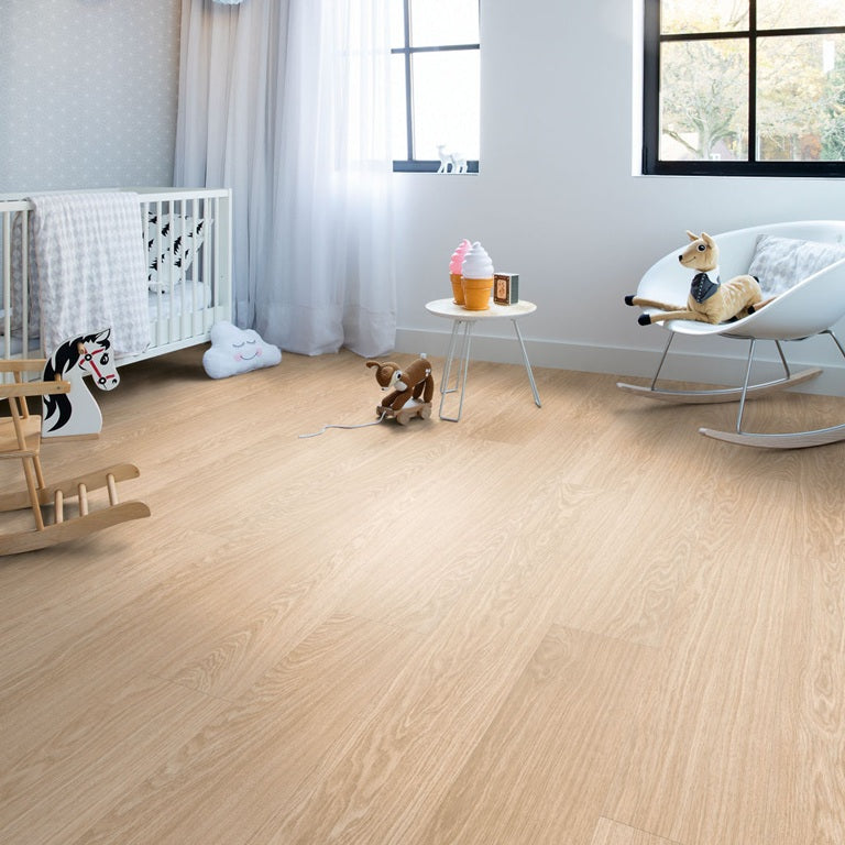 Kinderkamer met lichte Quick-Step PVC-vloer, babybedje, schommelstoel en speelgoed