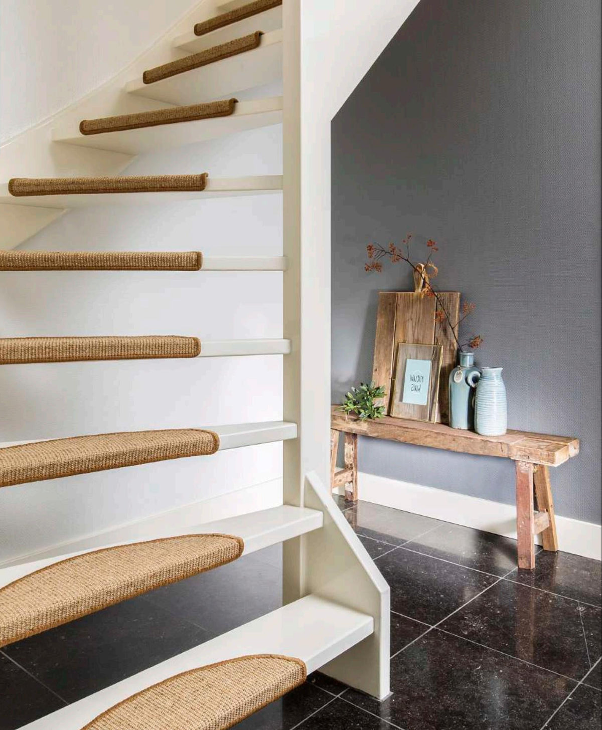 Open trap met natuurlijke sisal trapmaantjes van Hofmans at Home, stijlvol gecombineerd met wit hout en moderne afwerking, onderdeel van de grootste showroom van Nederland.