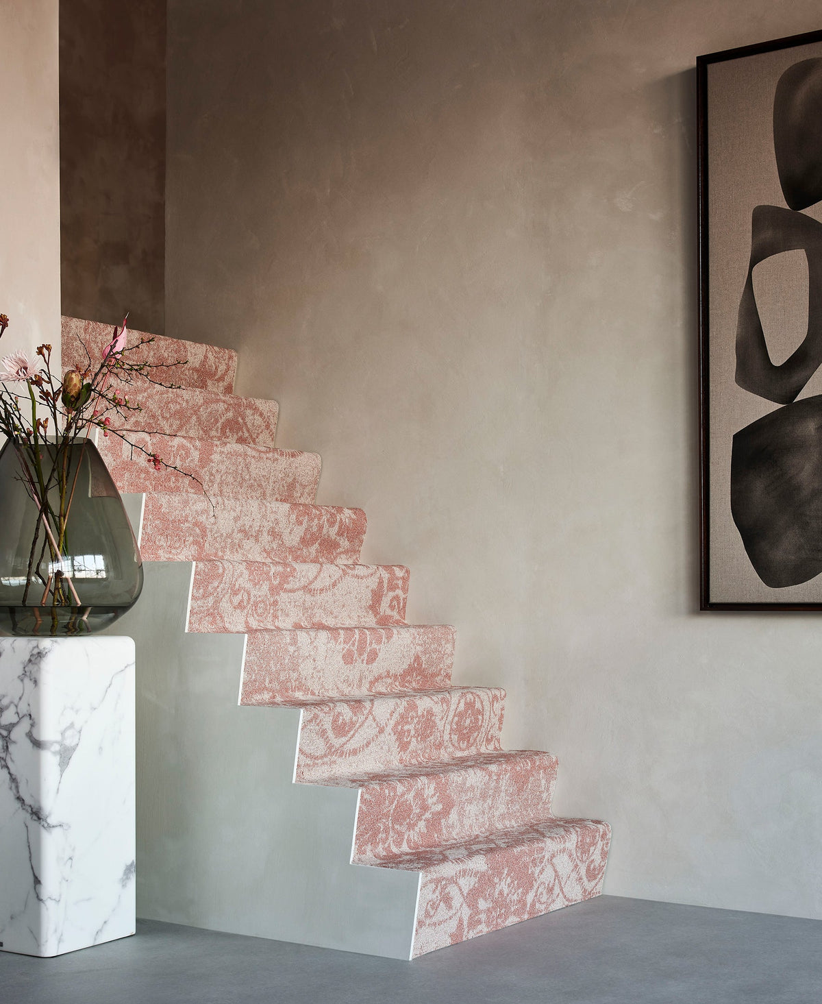 Trap met tapijt trapbekleding uit de Desso collectie bij Hofmans at Home, in moderne roze tint met subtiel patroon, onderdeel van de grootste showroom van Nederland.